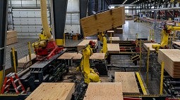 Mass timber panels being loaded by robot arm
