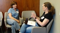 two women sitting across from each other having a conversation