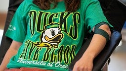 person donating blood wearing Ducks shirt