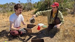 Students sifting dirt for artifacts at dig site