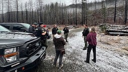 Students talking with law enforcement officers on a remote logging road