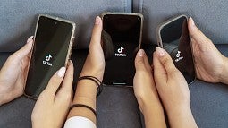 Three cellphones open to Tik Tok
