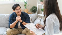 An Asian man talking to a therapist