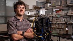 Student posing next to scuba gear