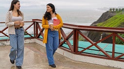 Two study abroad students walking near a coastline