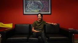 Tien-Tien Yu sitting on a sofa with a painting on the wall behind her