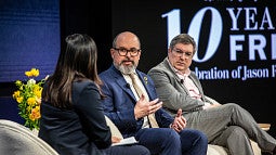 Three people on a stage talking