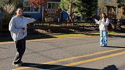 Two women stand outside historic lodge.