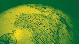 Map of the globe tinted green and yellow showing Australia