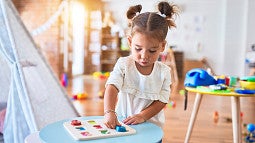 a child plays with a box of colorful items