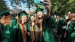 Students take a moment to get a selfie before parading down 13th avenue toward Matt Knight Arena