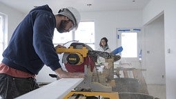 Student sawing baseboard
