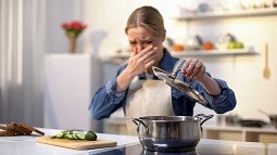 Woman reacts to smell of spoiled food