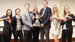 Evans Scholars holding trophy