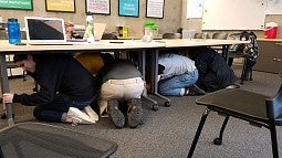 People crouching under desks