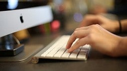 Hands typing on computer keyboard