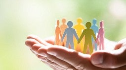 Hands holding paper-doll people