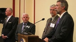 Brad Shelton, Scott Coltrane (at podium) and Randy Kamphaus (far left)