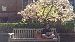 Freshman Odessa Cleavenger studies outside Knight Library on a beautiful spring afternoon.