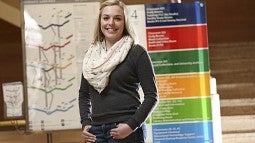 Jenna Mogstad, standing among some of the new signs she helped design, is a fourth-year interior architecture student.