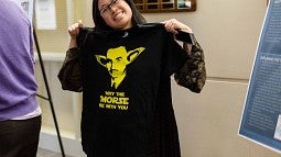Student holding t-shirt with slogan 'May the Morse be with you."