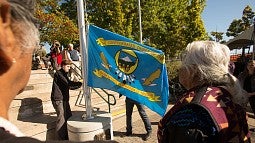 Raising one of the nine tribal flags around the EMU amphitheater