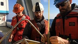 Photo of two UO grad students prepping a seismometer for deployment