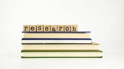 Blocks spelling out research on top of a stack of books