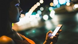 Woman with cellphone at night