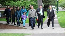 President Michael Schill and others walking across campus to deliver an award.