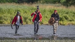 Students wading a river in Alaska