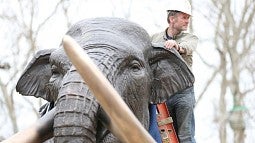 Artist on mammoth sculpture