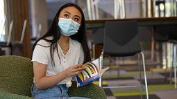 Masked student reading book