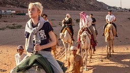 Students riding camels in Jordan