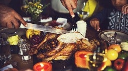 Hands carving a Thanksgiving turkey