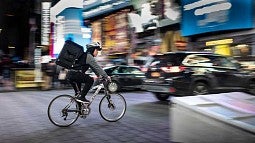 Bicycle delivery person on city street