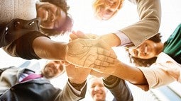 People with hands extended in a circle