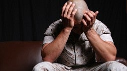 Veteran holding head in hands