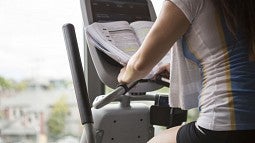 Woman studying on exercise machine