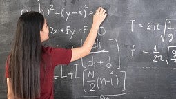 Woman doing math on blackboard