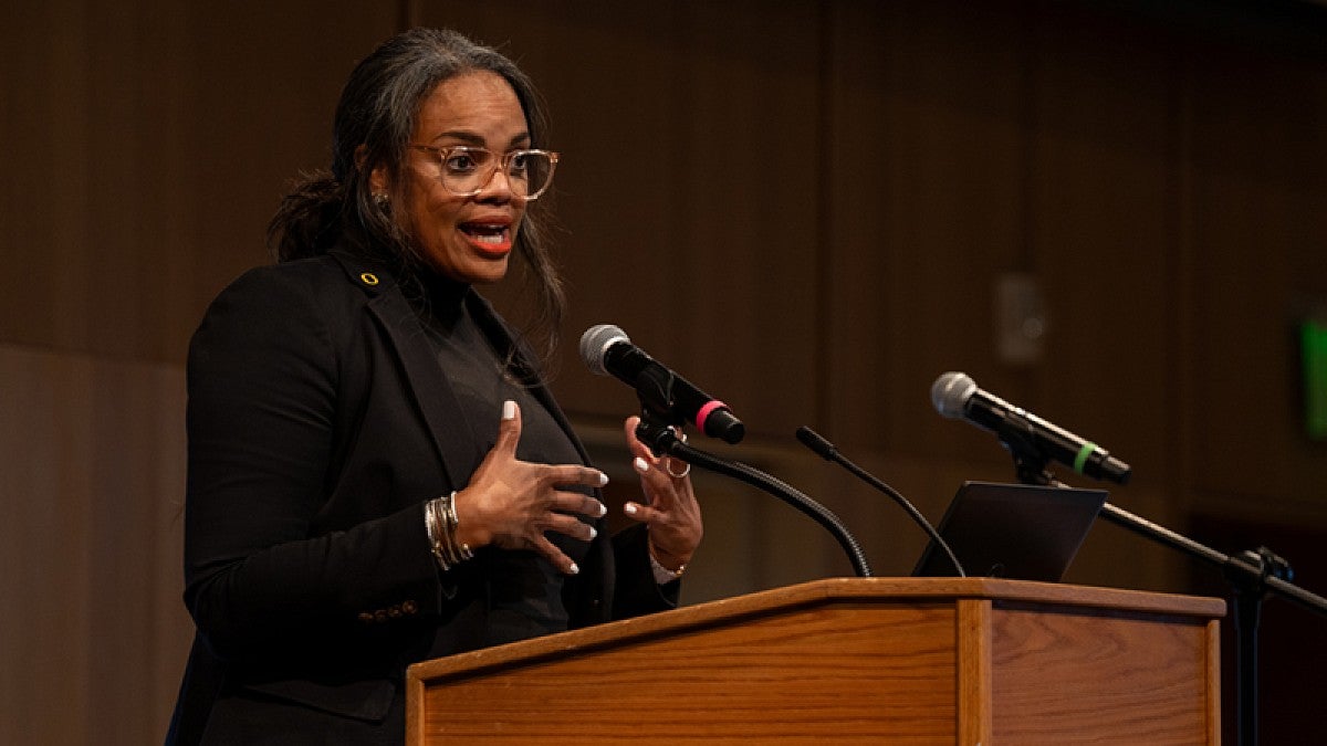 Lesley-Anne Pittard speaks at podium in ballroom