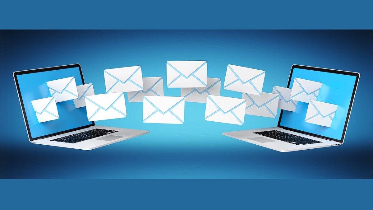 two laptops with email envelopes floating in between