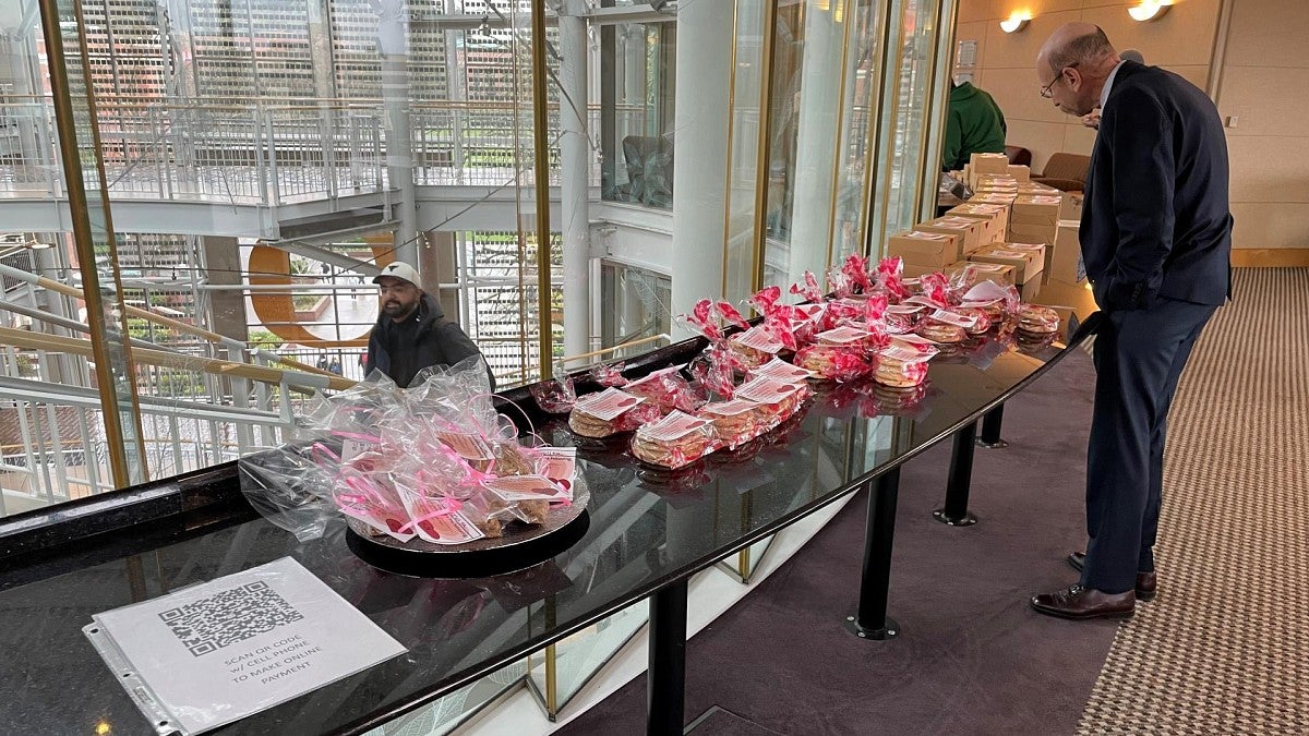 A man looks over baked goods on a table