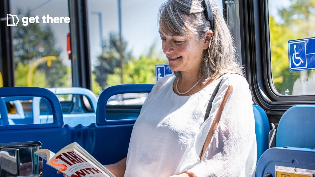 woman reading a book riding the bus