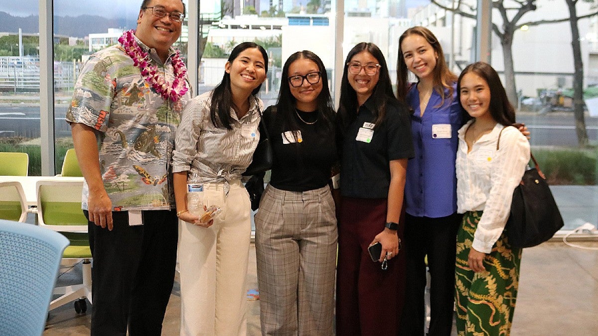 Jade Ishimine posing in a group with four additional female interns and a male mentor who is wearing a Hawaiian shirt and lei.