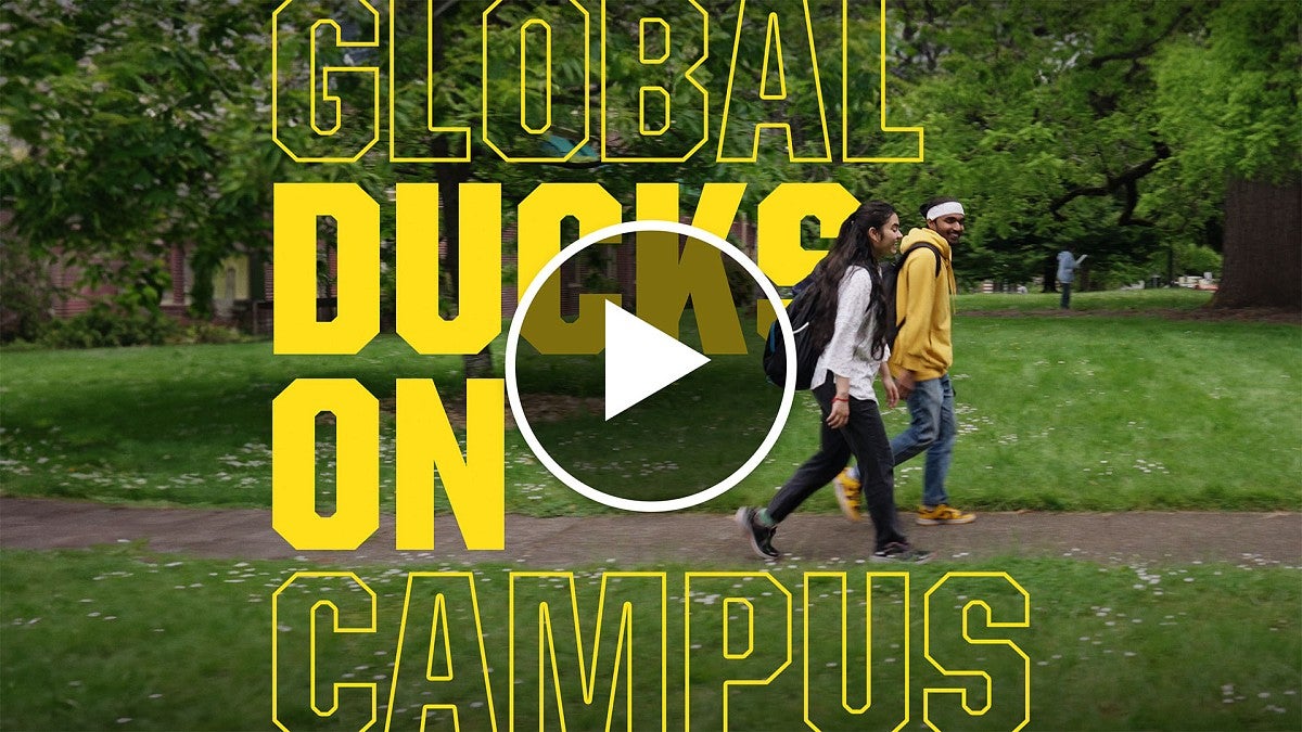 Students walking on campus, with video play button