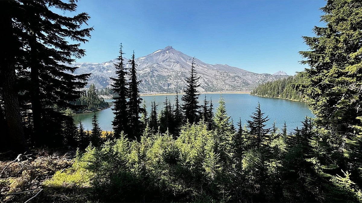 A view of the South Sister with lake and forest in foreground