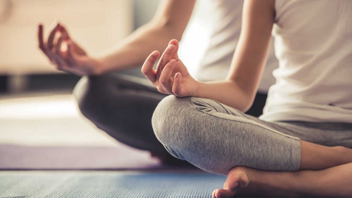 two people seated in a yoga pose