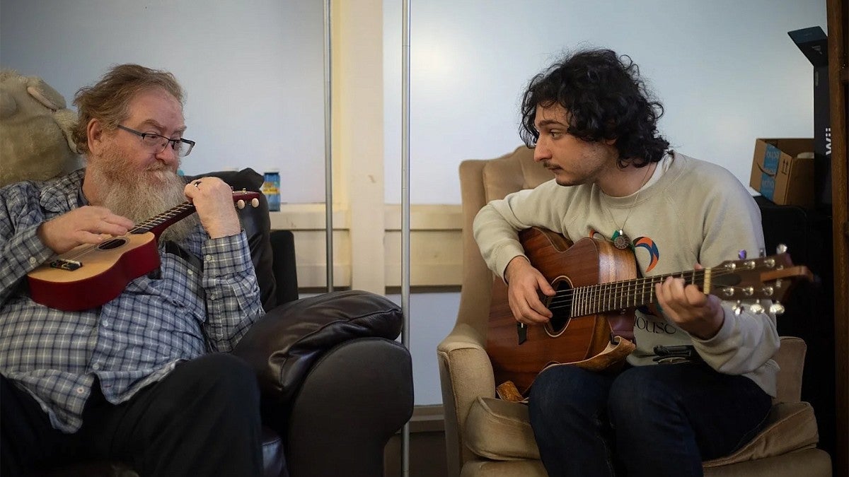 Micah Primack teaches chords to a ukulele student