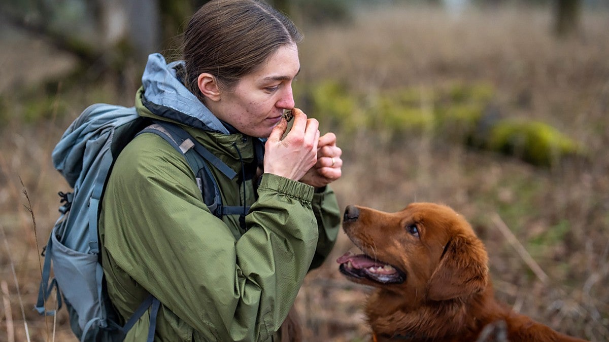 Heather Dawson sniffing a truffle with dog Rye watching